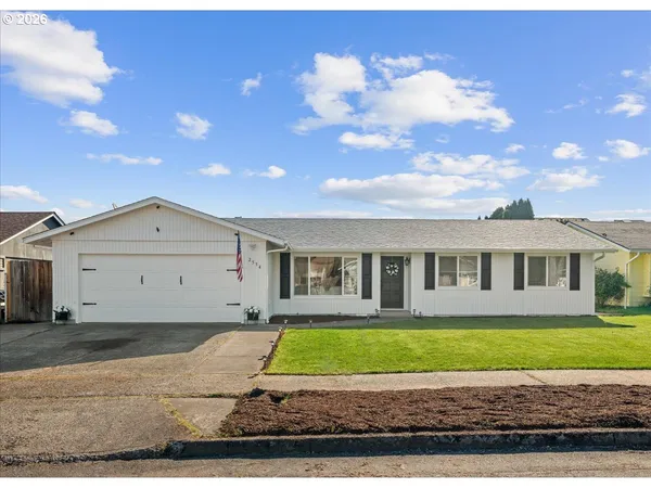 a front view of a house with a yard and potted plants