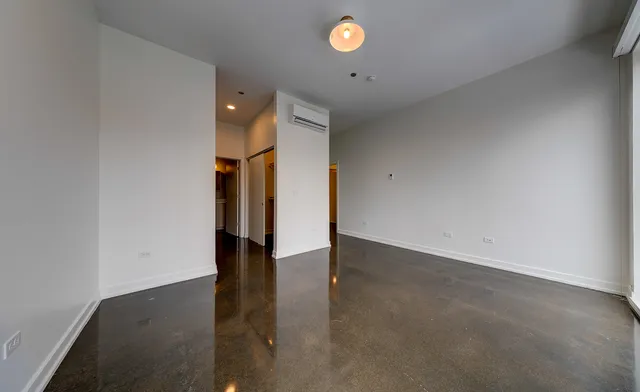 an empty room with wooden floor and entryway