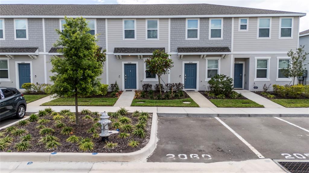2060 Viewfinder Street Kissimmee, FL 34758 - Photo 2 of 23 a view of a white house with a small yard plants and a lawn chairs