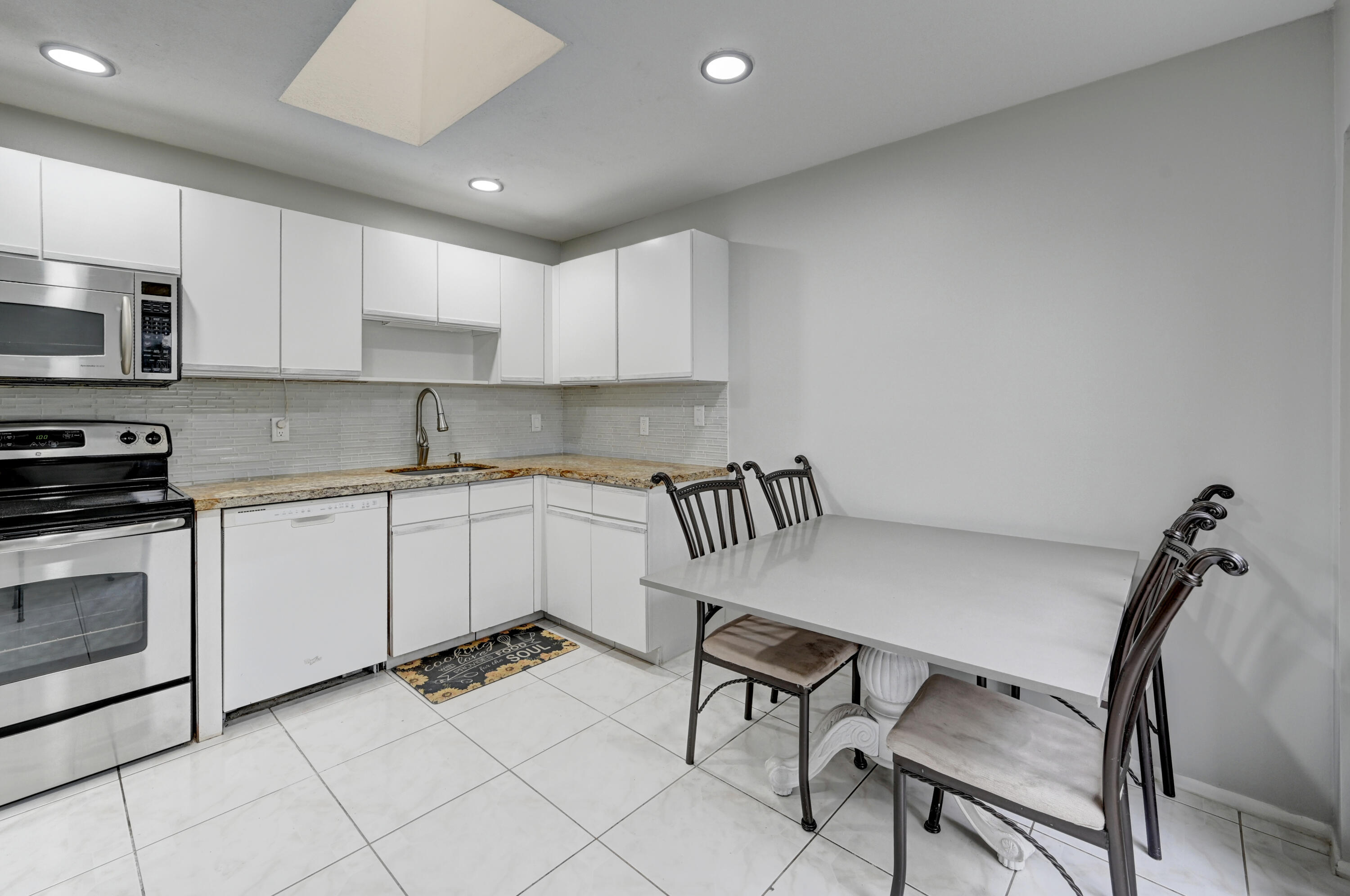 23328 Southwest 58th Avenue, Unit C Boca Raton, FL 33428 - Photo 11 of 35 a kitchen with a stove cabinets and a sink