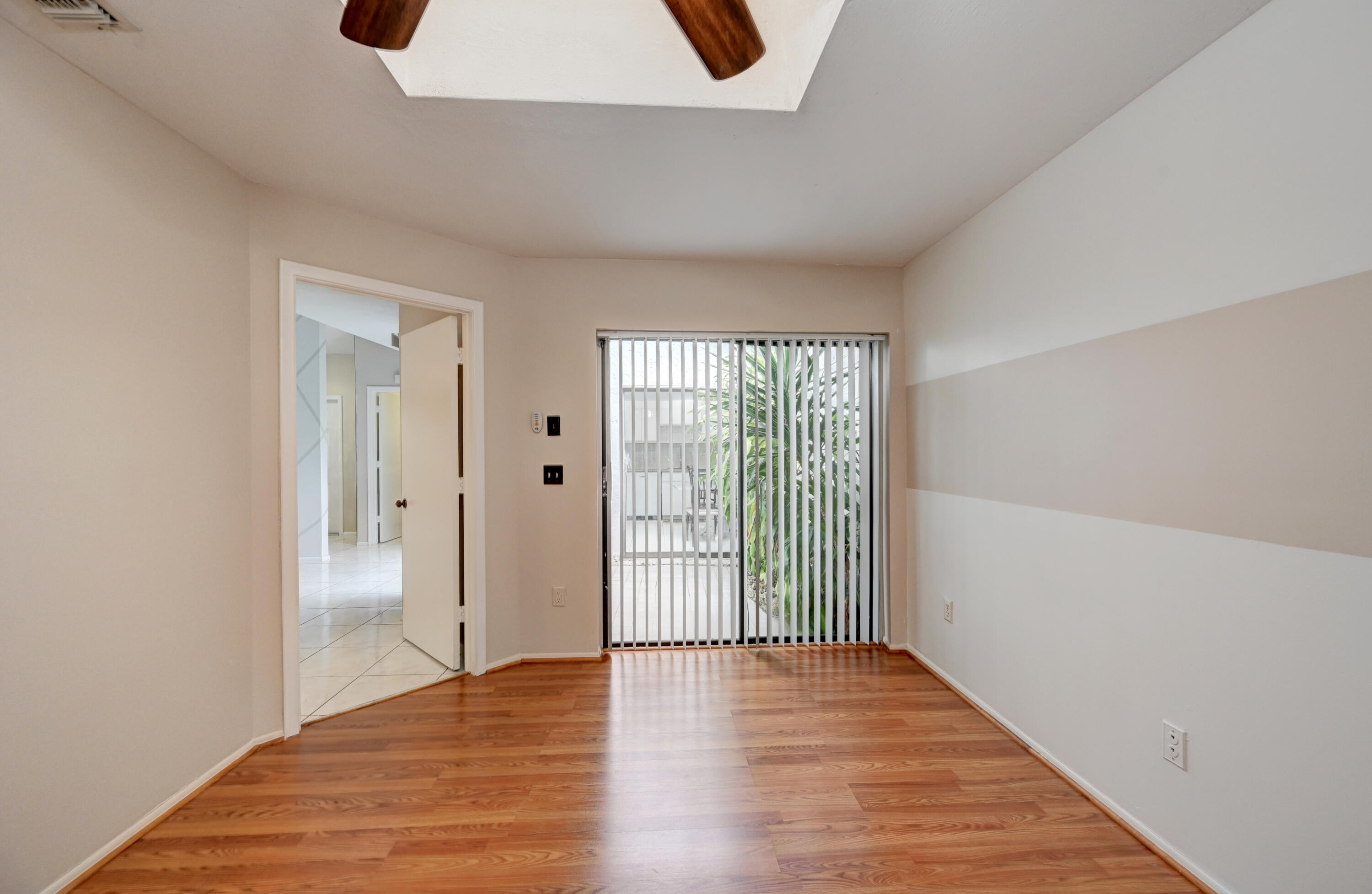 23328 Southwest 58th Avenue, Unit C Boca Raton, FL 33428 - Photo 20 of 35 a view of an empty room with wooden floor and a window