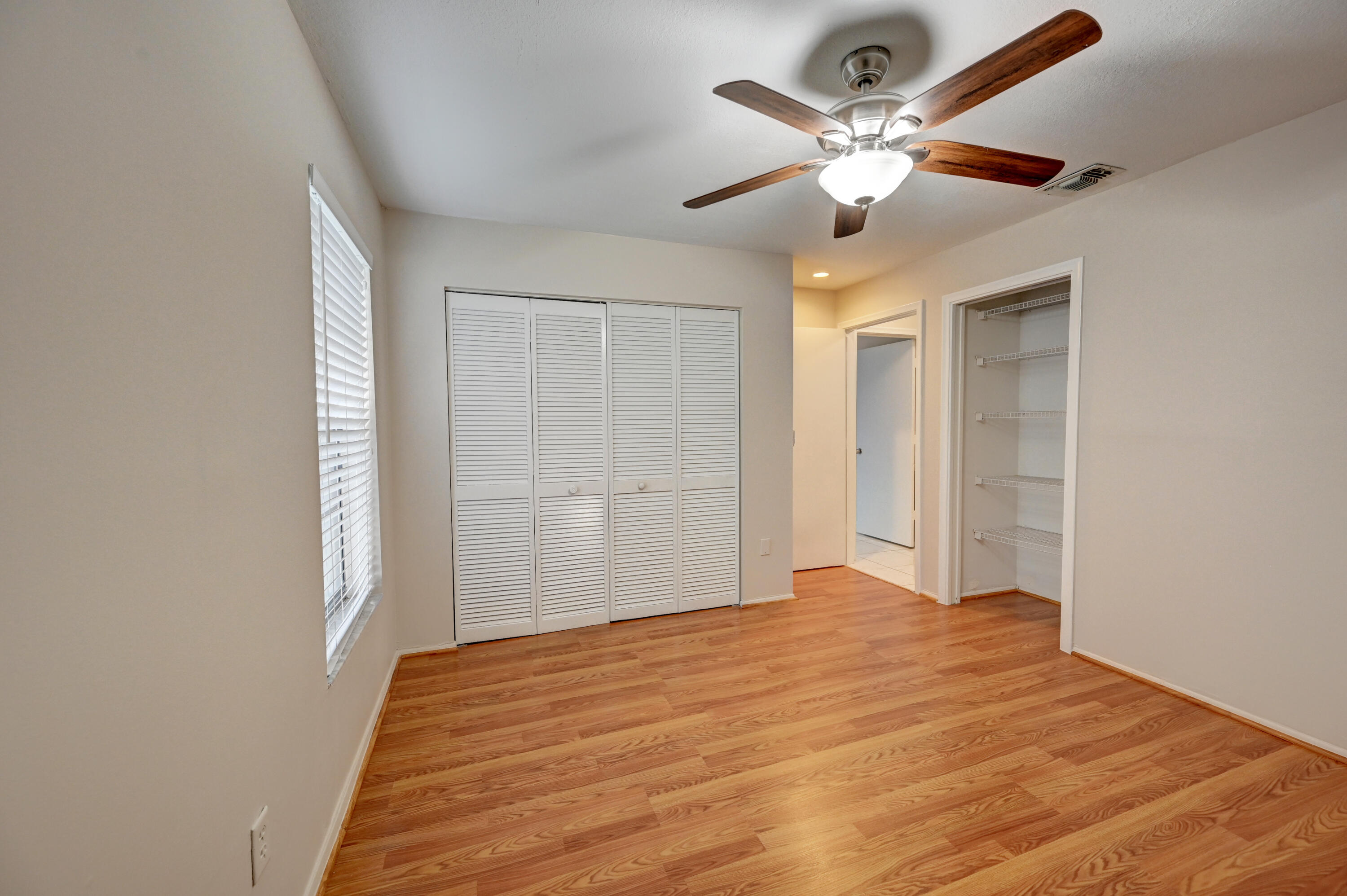 23328 Southwest 58th Avenue, Unit C Boca Raton, FL 33428 - Photo 22 of 35 a bedroom with a large bed and a chandelier