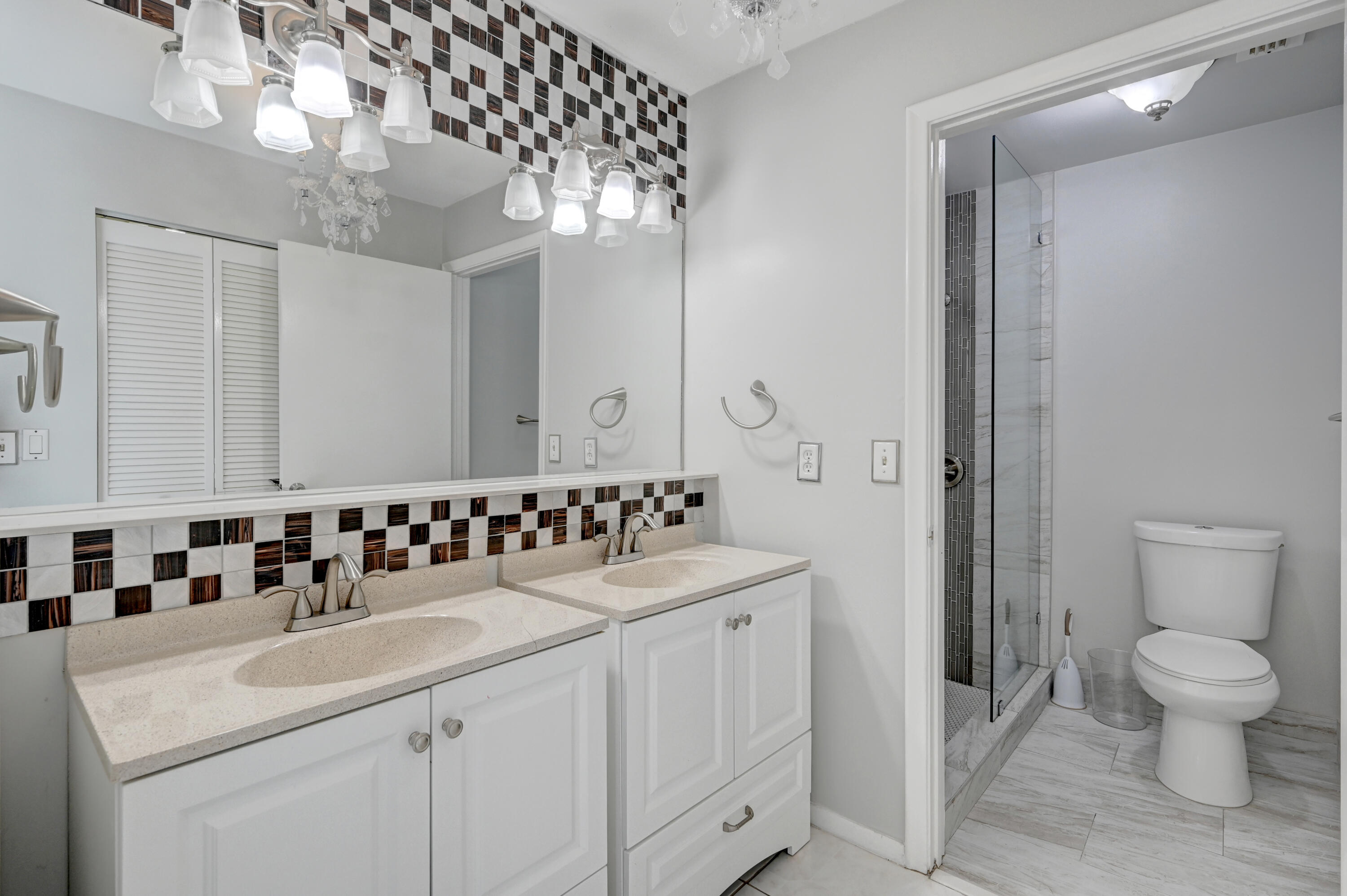 23328 Southwest 58th Avenue, Unit C Boca Raton, FL 33428 - Photo 25 of 35 a bathroom with a sink a toilet and a large mirror