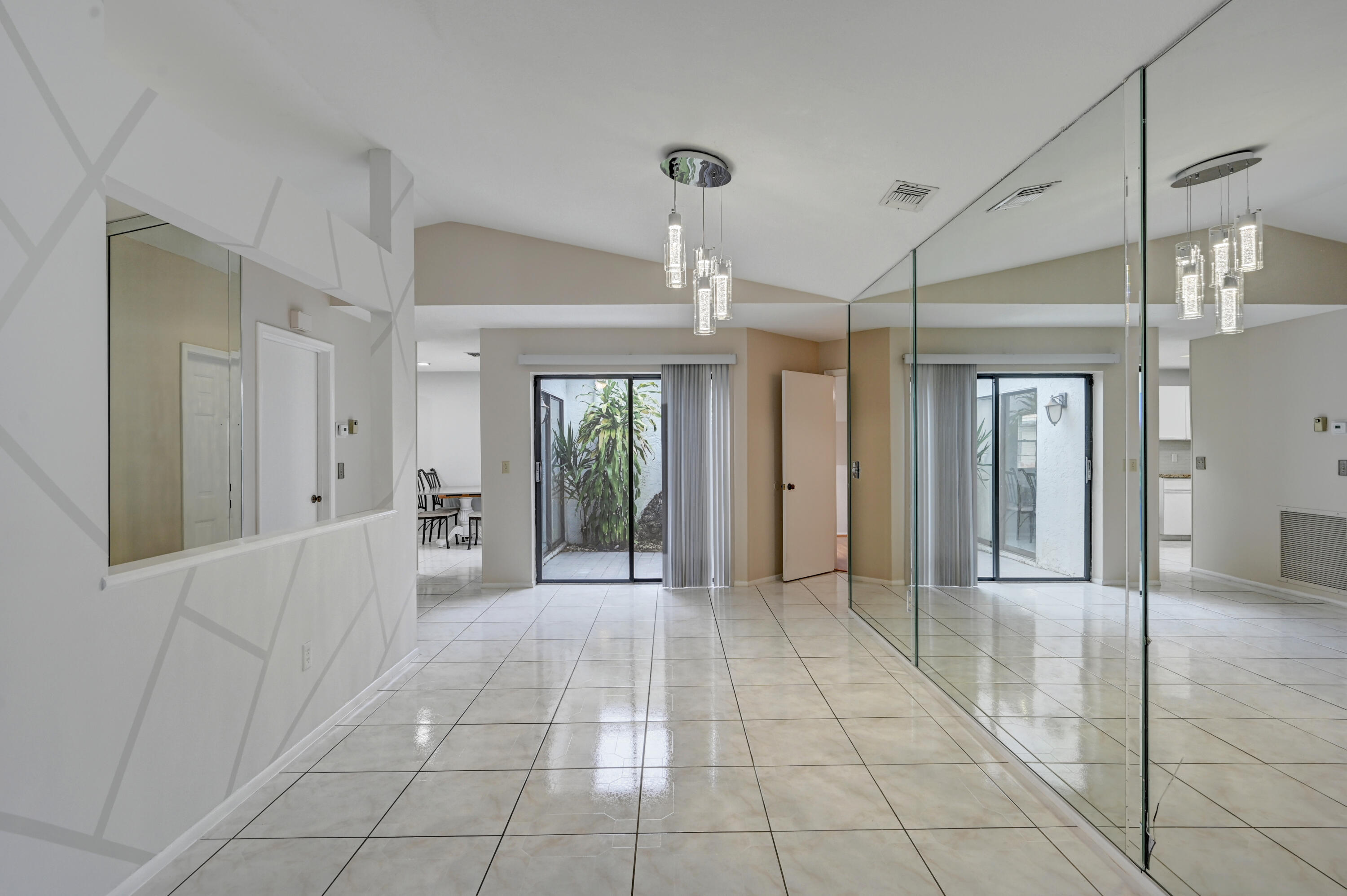 23328 Southwest 58th Avenue, Unit C Boca Raton, FL 33428 - Photo 8 of 35 a view of a hallway with wooden floor and a chandelier