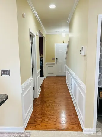 a view of a hallway with wooden floor and staircase