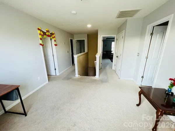a view of a hallway with furniture and a window