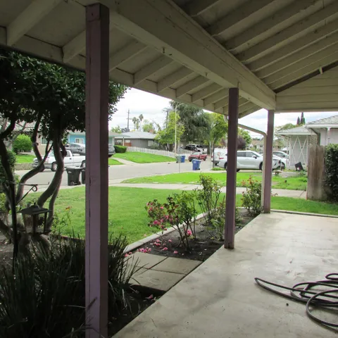 a view of a porch with furniture and garden