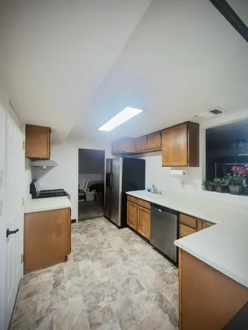 a large room with kitchen island a sink a stove and a refrigerator