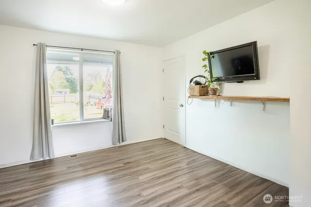 a view of a livingroom with wooden floor and a flat screen tv