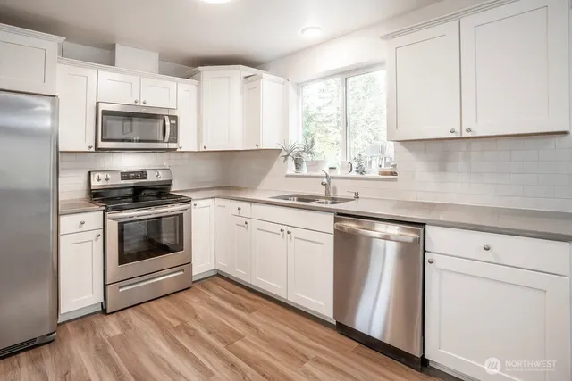 a kitchen with white cabinets stainless steel appliances and sink