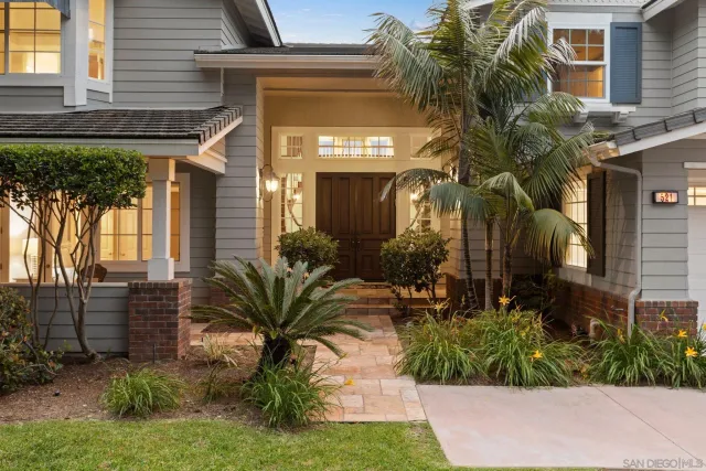 a view of a house with a yard and potted plants