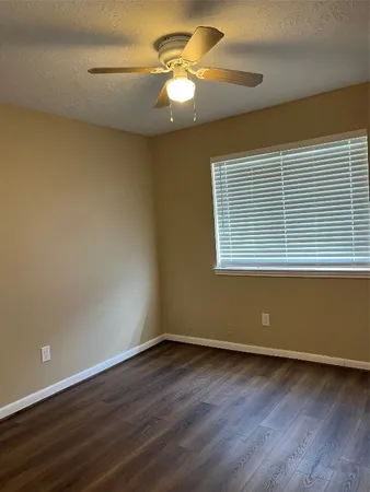 a view of a room with wooden floor and a window
