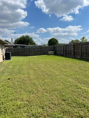 a view of a yard with wooden fence