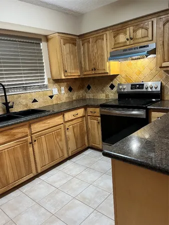 a kitchen with stainless steel appliances granite countertop a sink and a stove