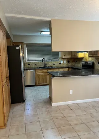 a kitchen with stainless steel appliances granite countertop a refrigerator and a stove