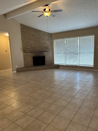 an empty room with windows and chandelier fan