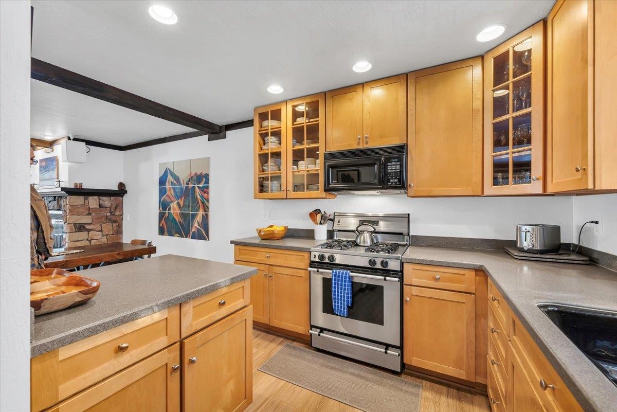 227 Olympic Vly Road, Unit 15 Olympic Valley, CA 96146 - Photo 6 of 28 a kitchen with stainless steel appliances granite countertop a stove a sink and a microwave