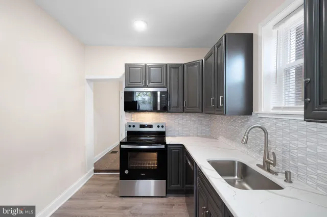 a kitchen with stainless steel appliances a sink a stove and microwave