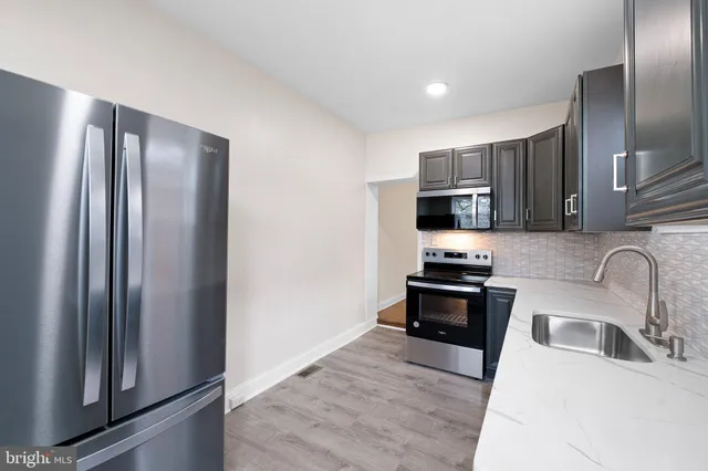 a kitchen with stainless steel appliances granite countertop a refrigerator stove and sink