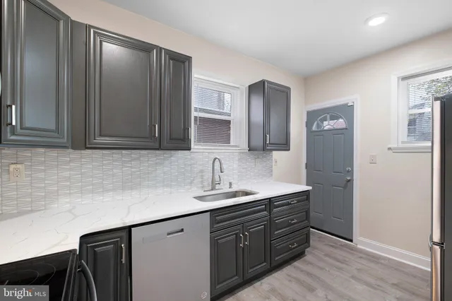 a kitchen with a sink cabinets and wooden floor