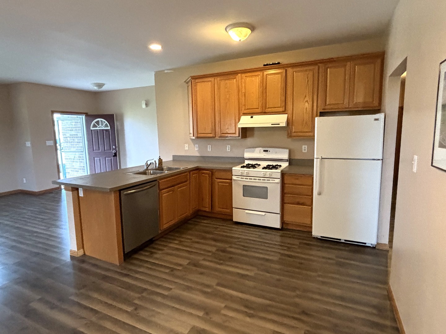 1923 Taller Road, Unit 1923 Morris, IL 60450 - Photo 5 of 12 a kitchen with stainless steel appliances granite countertop a stove top oven a refrigerator a sink and dishwasher with wooden floor