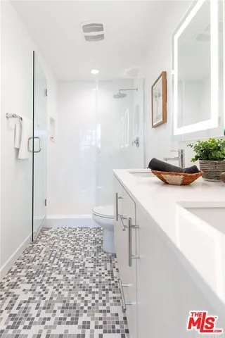 a bathroom with a sink a mirror and a shower