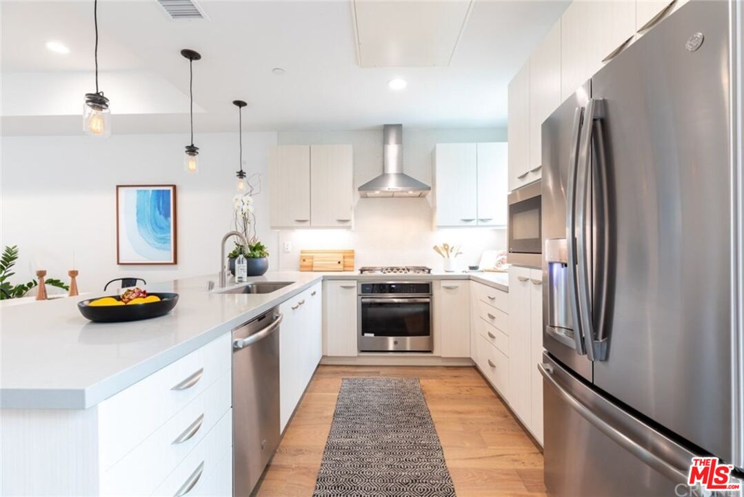 4821 1/2 Craner Avenue North Hollywood, CA 91601 - Photo 6 of 14 a kitchen with stainless steel appliances a stove a sink and a refrigerator