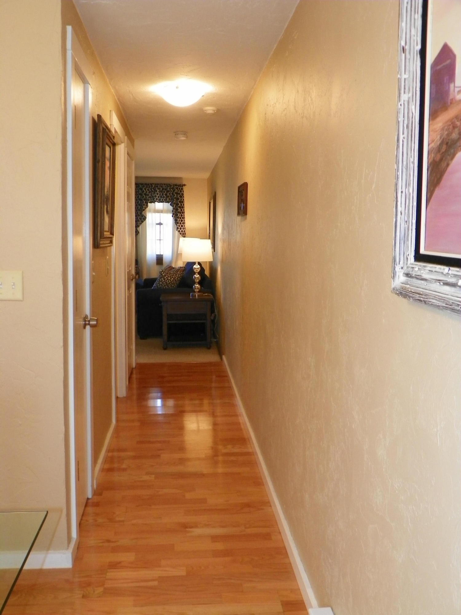 300 Falmouth Road, Unit 6E Mashpee, MA 02649 - Photo 12 of 32 a view of a hallway with wooden floor and a living room