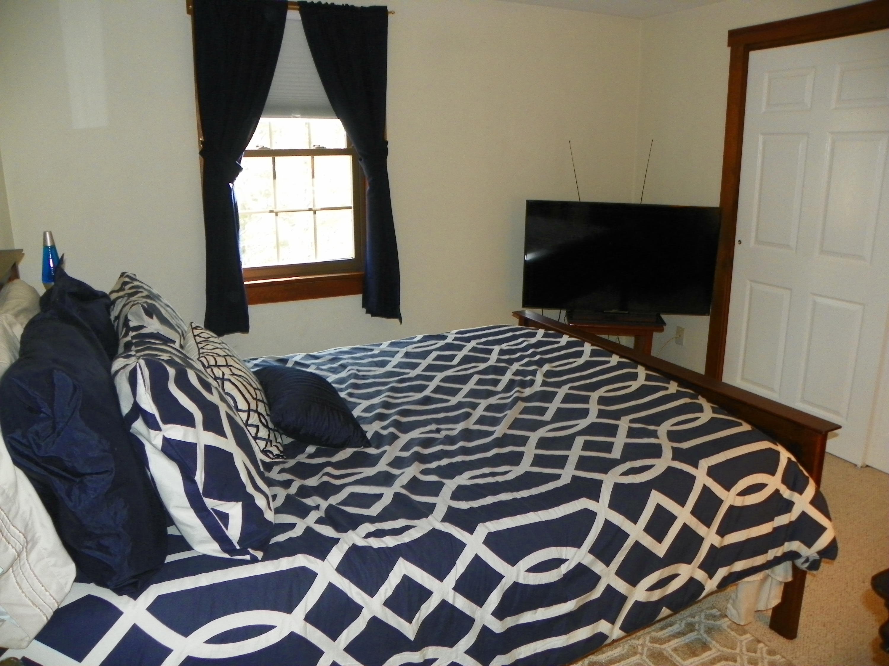 300 Falmouth Road, Unit 6E Mashpee, MA 02649 - Photo 19 of 32 a bedroom with a bed and wooden floor