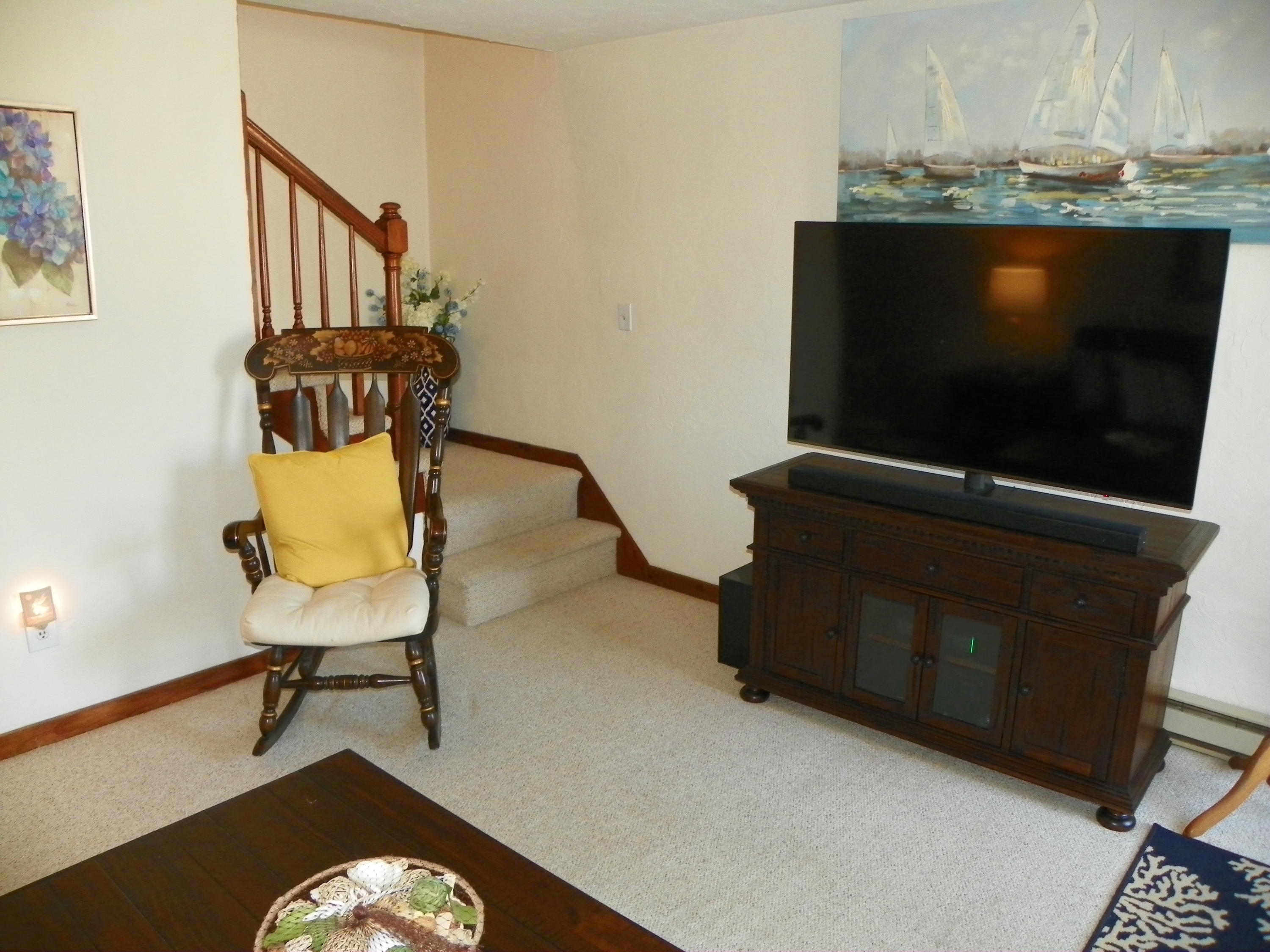 300 Falmouth Road, Unit 6E Mashpee, MA 02649 - Photo 3 of 32 a living room with furniture and a flat screen tv