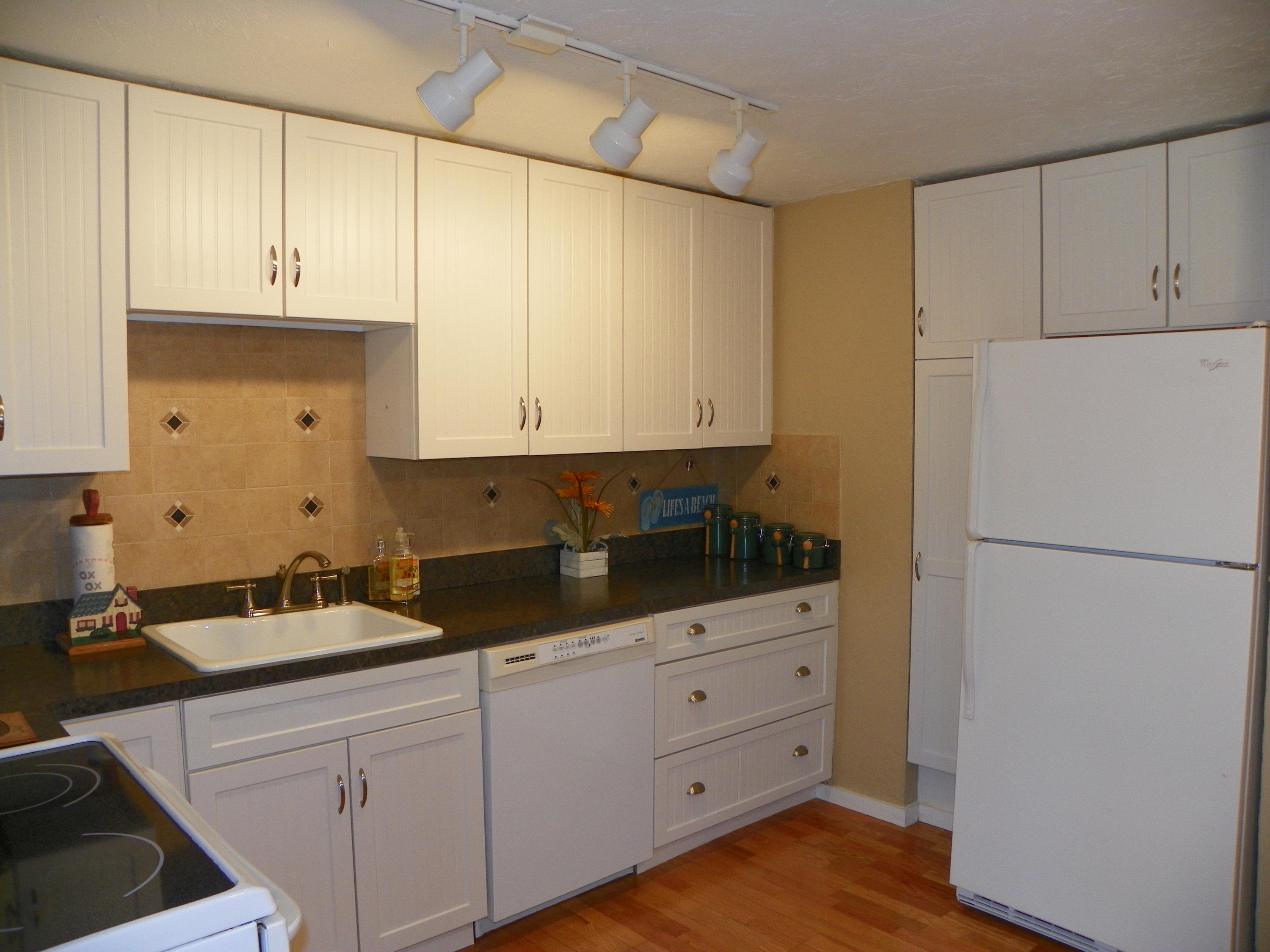 300 Falmouth Road, Unit 6E Mashpee, MA 02649 - Photo 10 of 32 a kitchen with granite countertop white cabinets and white appliances