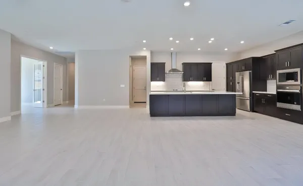 a view of kitchen with kitchen island stainless steel appliances a sink and a stove
