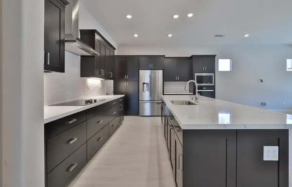 a large kitchen with stainless steel appliances a large counter top