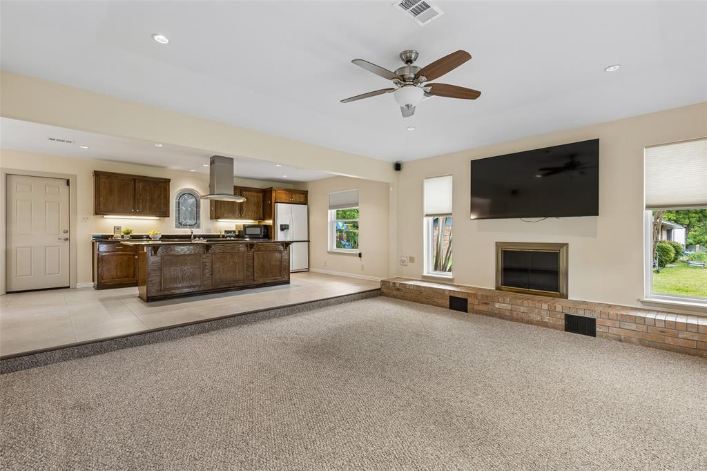 1548 Timbercreek Drive Howe, TX 75459 - Photo 3 of 24 a view of a livingroom with a flat screen tv a ceiling fan and a kitchen