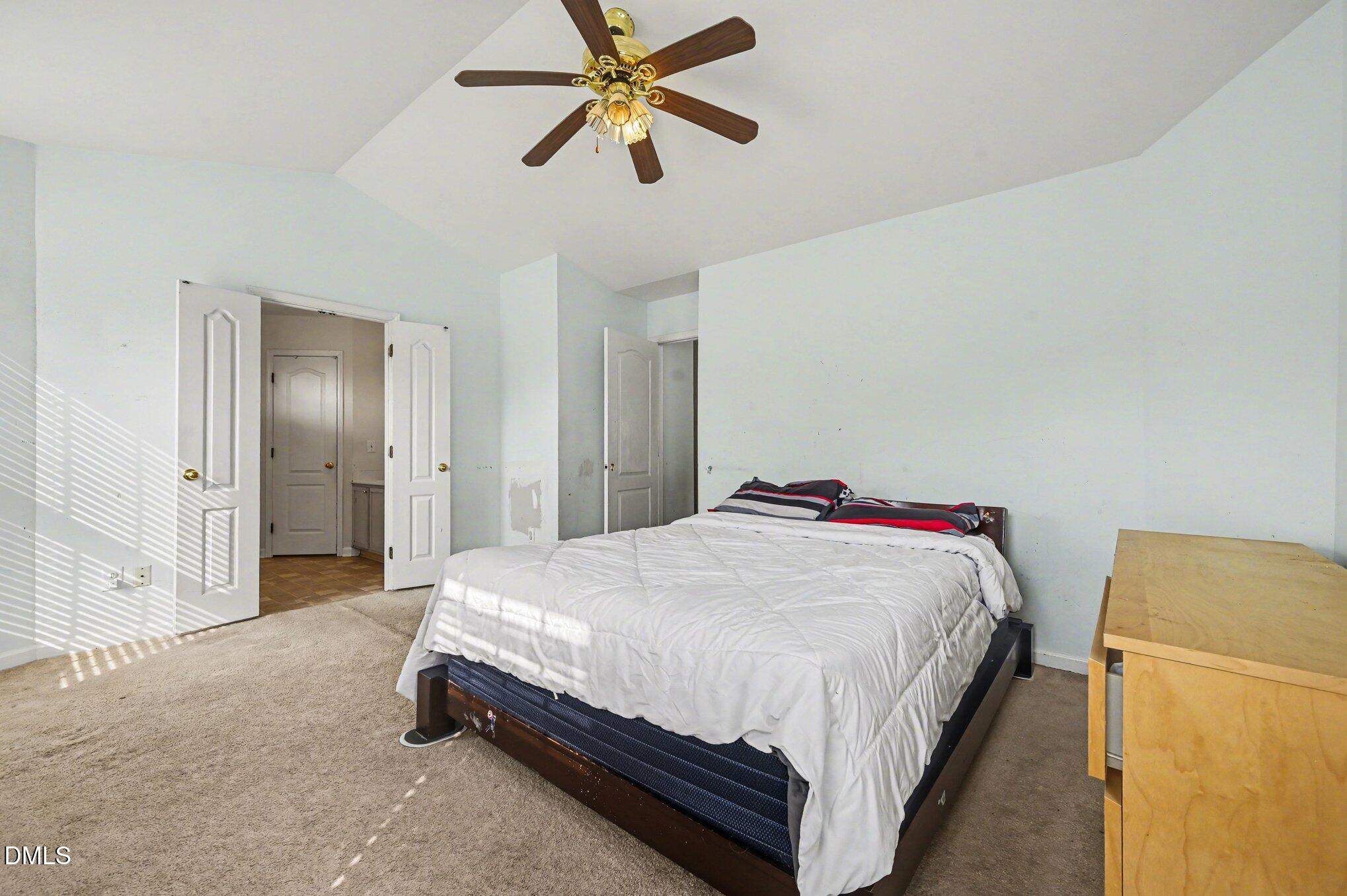 5115 Cardinal Grove Boulevard Raleigh, NC 27616 - Photo 20 of 36 a spacious bedroom with a bed and a chandelier