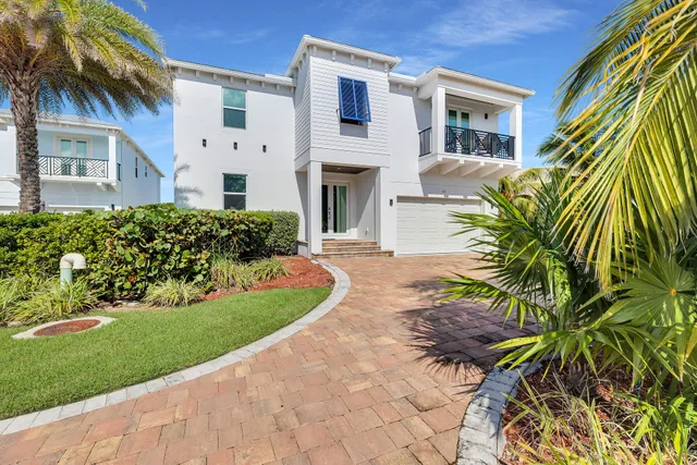 a view of a house with a yard and palm trees
