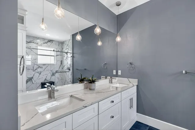 a bathroom with a granite countertop bathtub sink vanity mirror and toilet