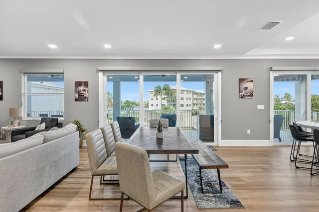 a view of kitchen with stainless steel appliances granite countertop sink stove dining table and chairs