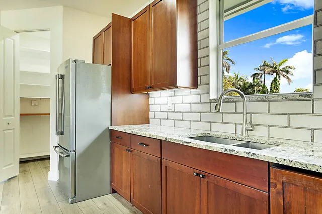 a kitchen with stainless steel appliances granite countertop a refrigerator and a sink