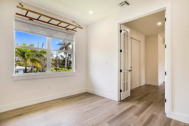 a view of a hallway with wooden floor and front door