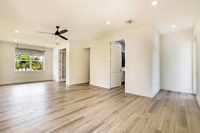 a view of an empty room with window and wooden floor