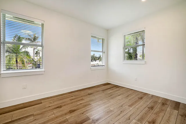 a view of a room that has wooden floor and window in it
