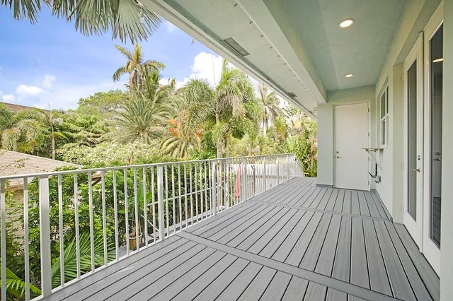 a view of a balcony with wooden floor and fence