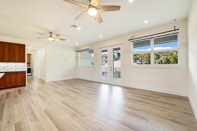 a view of an empty room with a window and wooden floor