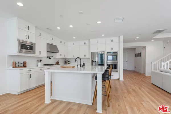 a kitchen with stainless steel appliances sink a microwave and cabinets