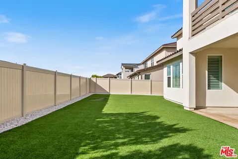 a front view of residential houses with yard and mountain view in back