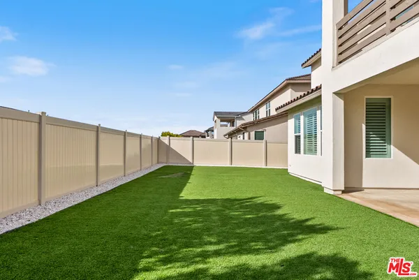 a front view of residential houses with yard and mountain view in back