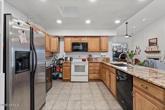 a kitchen with stainless steel appliances granite countertop a refrigerator and a stove top oven