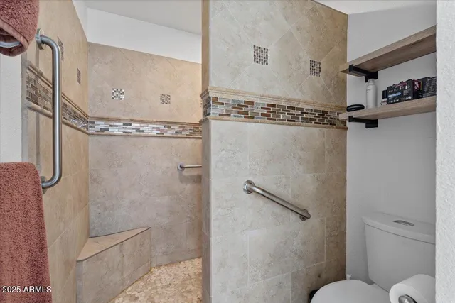 a bathroom with a granite countertop shower sink and toilet