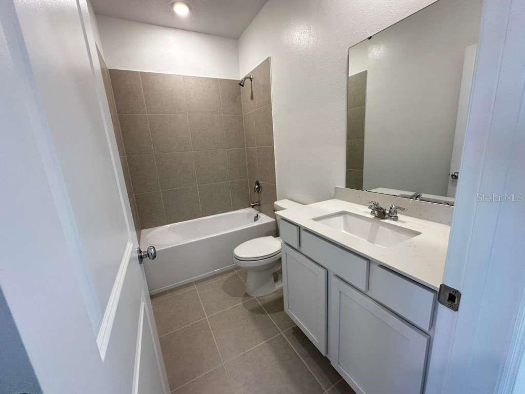 2729 Skyline Loop Kissimmee, FL 34758 - Photo 14 of 20 a bathroom with a double vanity sink toilet mirror and shower
